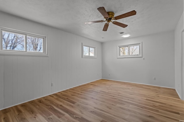 spare room with ceiling fan, a textured ceiling, and wood finished floors