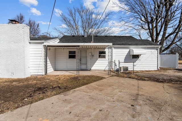 rear view of property featuring a patio area, fence, and a chimney