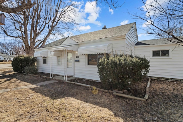 rear view of house with roof with shingles