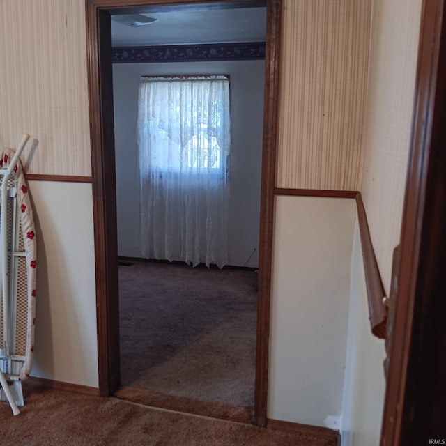 hallway with carpet floors and wallpapered walls