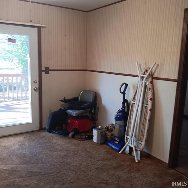 doorway to outside featuring carpet floors, plenty of natural light, and ornamental molding