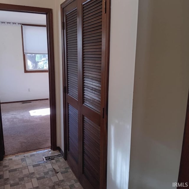 hallway featuring carpet floors and visible vents