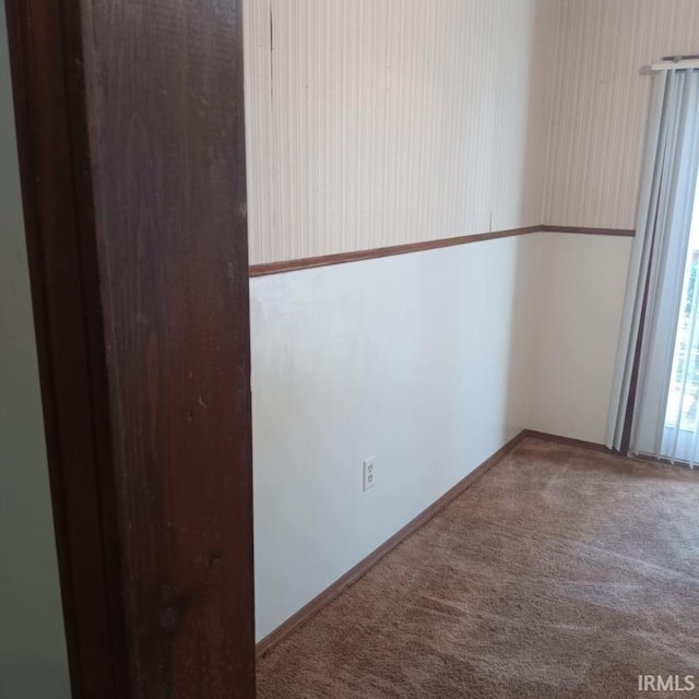 carpeted empty room featuring baseboards