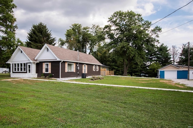 view of front of home with central air condition unit, a shingled roof, a detached garage, an outdoor structure, and a front yard