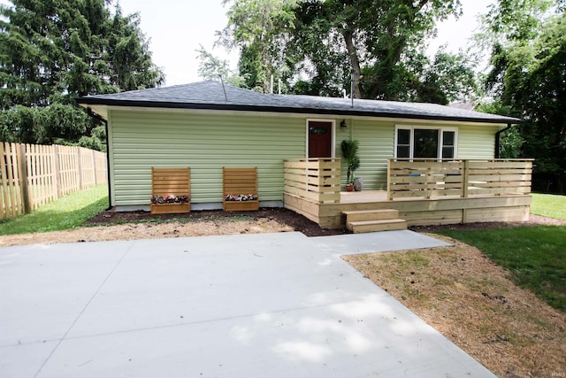 ranch-style home featuring a patio area, fence, and a wooden deck