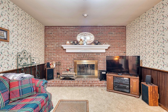 living area with carpet, a wainscoted wall, a fireplace, and wallpapered walls