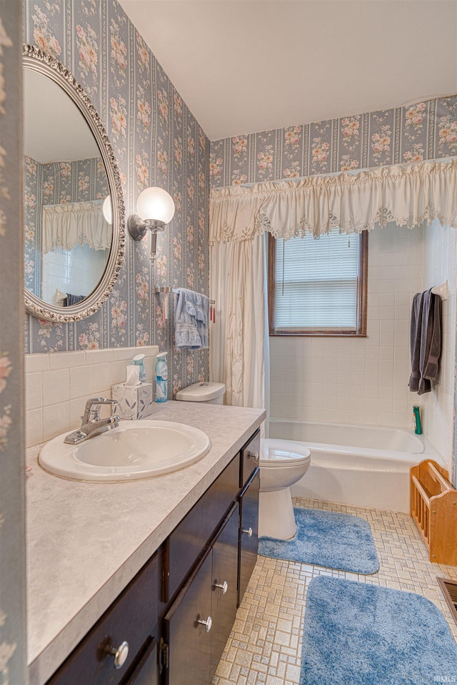 bathroom featuring tile patterned flooring, toilet, vanity, shower / bath combo with shower curtain, and wallpapered walls