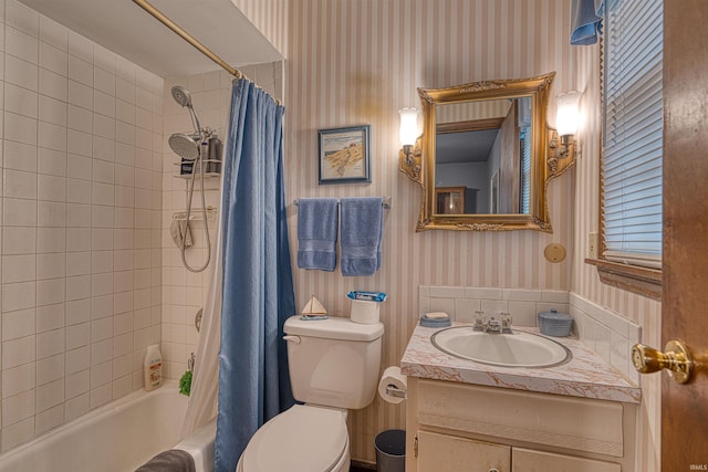 full bathroom featuring vanity, shower / bath combo with shower curtain, toilet, and wallpapered walls