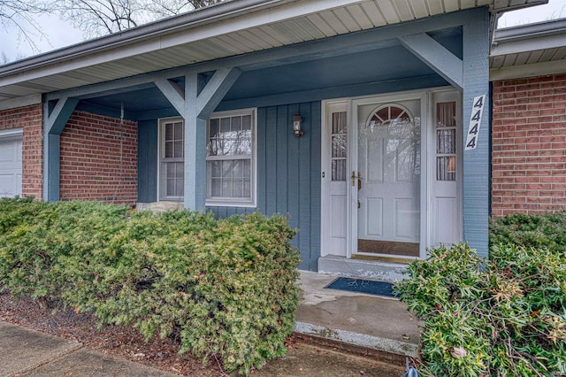 property entrance featuring brick siding and an attached garage