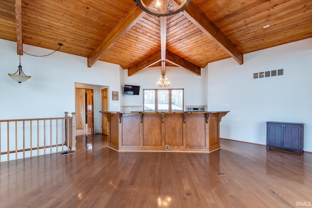 kitchen with brown cabinetry, wood finished floors, visible vents, and an inviting chandelier