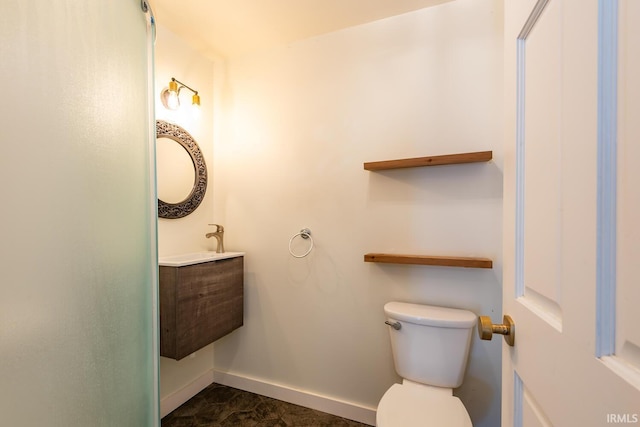 bathroom with toilet, baseboards, and vanity