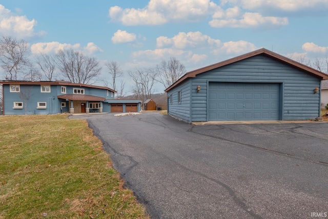 view of front of home with an outbuilding, a front lawn, and a detached garage