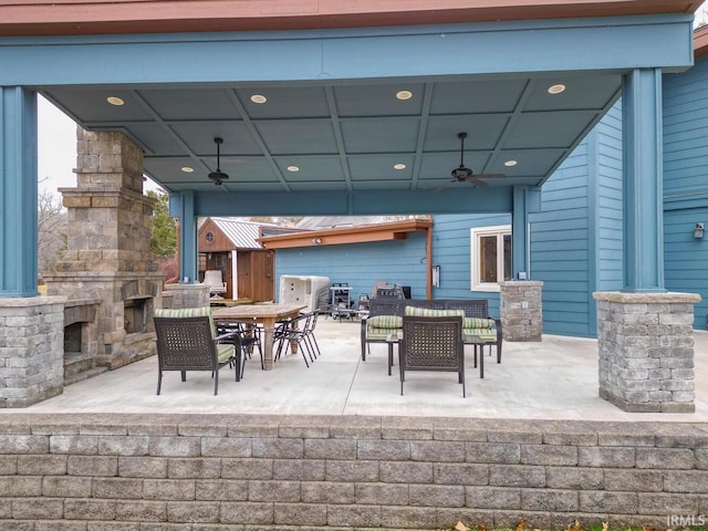 view of patio / terrace with a ceiling fan, outdoor dining area, and an outdoor living space with a fireplace