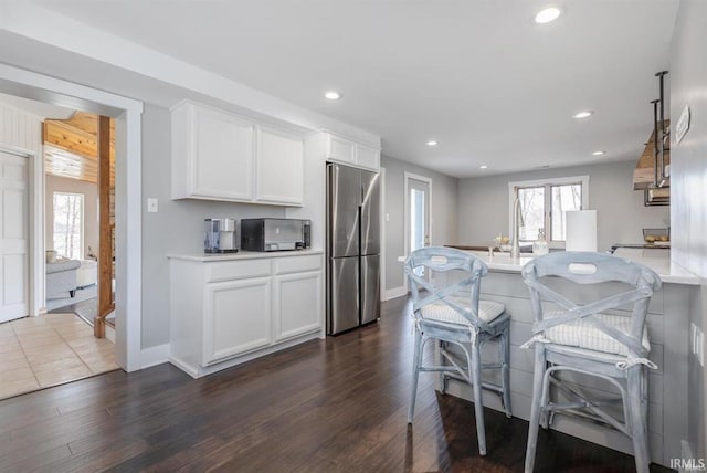 kitchen with dark wood-style floors, stainless steel fridge, and plenty of natural light