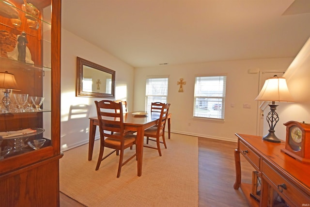 dining space with baseboards and wood finished floors