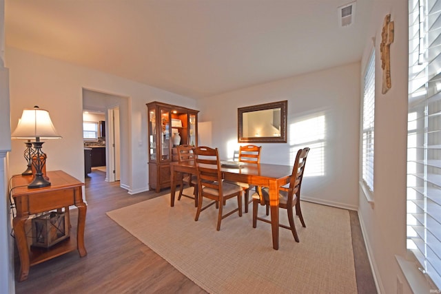 dining room featuring visible vents, baseboards, and wood finished floors