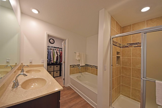 bathroom with wood finished floors, a sink, a shower stall, and a bath