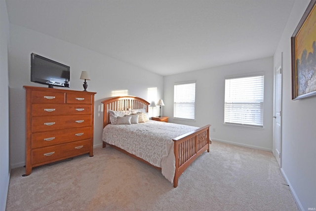 bedroom featuring vaulted ceiling, baseboards, and light colored carpet