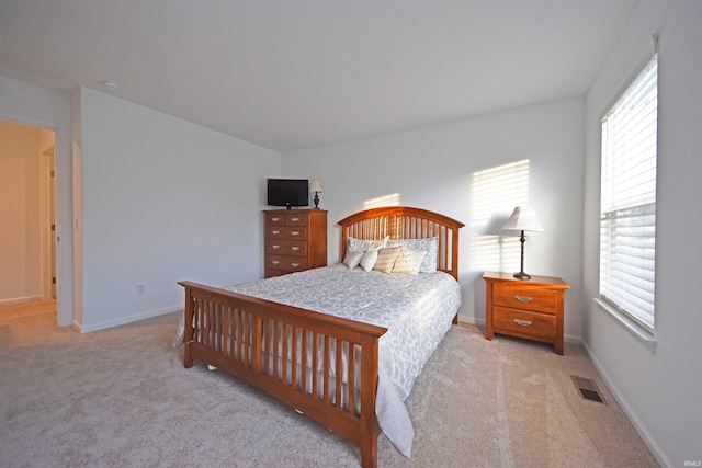 bedroom with light colored carpet, visible vents, and baseboards