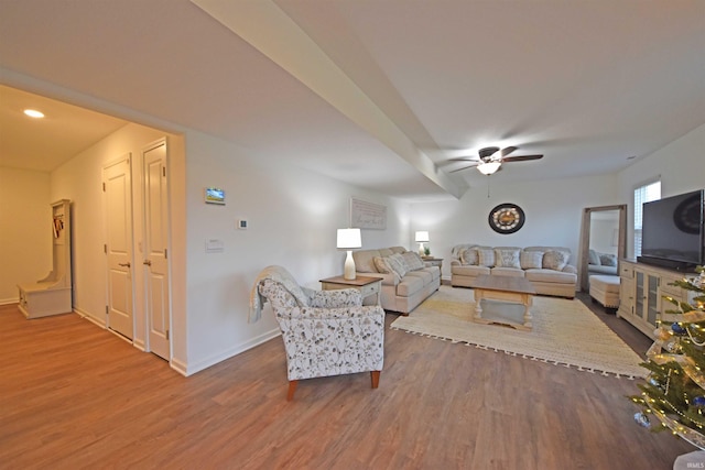 living room with wood finished floors, a ceiling fan, and baseboards