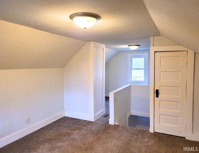 additional living space with carpet, baseboards, vaulted ceiling, and a textured ceiling