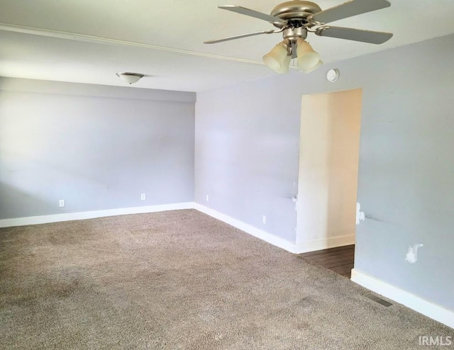 spare room featuring carpet, visible vents, and baseboards