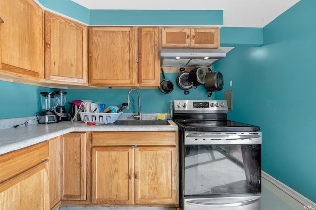 kitchen featuring light countertops, stainless steel electric range oven, under cabinet range hood, and a sink