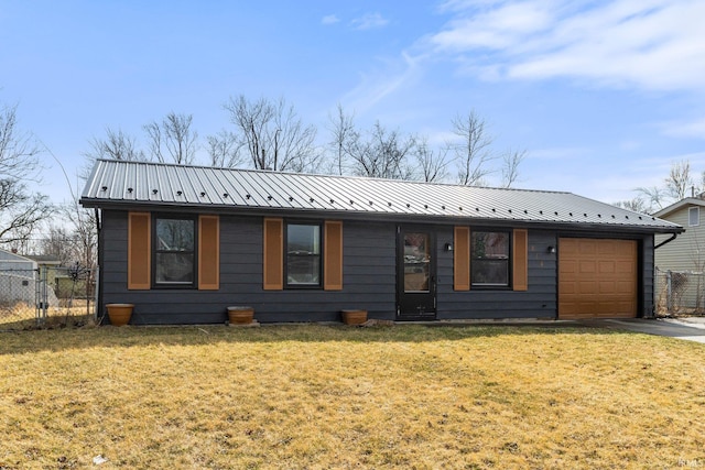 ranch-style home with a garage, concrete driveway, metal roof, fence, and a front lawn