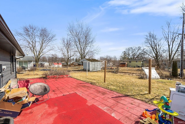 view of patio with an outbuilding, fence, and a storage unit