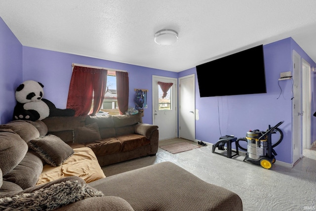 carpeted living room with a textured ceiling and baseboards