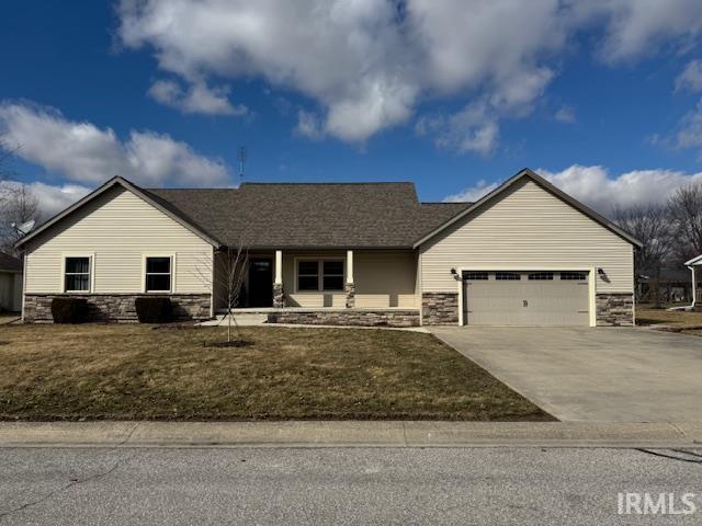 ranch-style house featuring a garage, stone siding, a front lawn, and concrete driveway