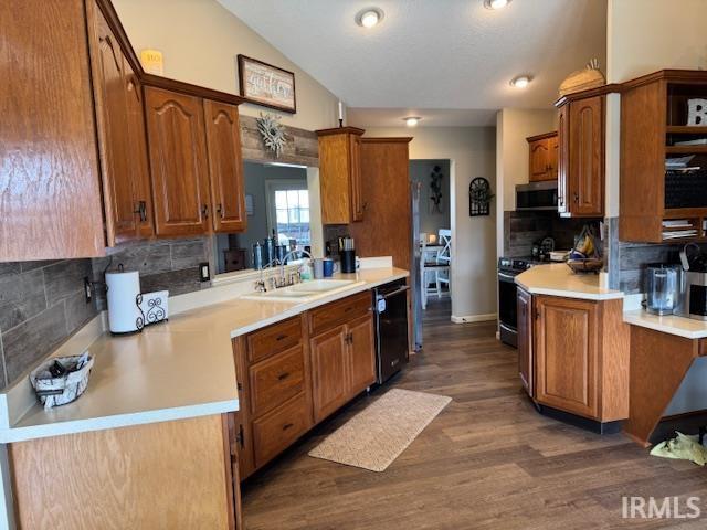 kitchen featuring a sink, light countertops, range, dishwasher, and stainless steel microwave