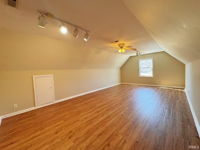 additional living space featuring wood finished floors, visible vents, and baseboards