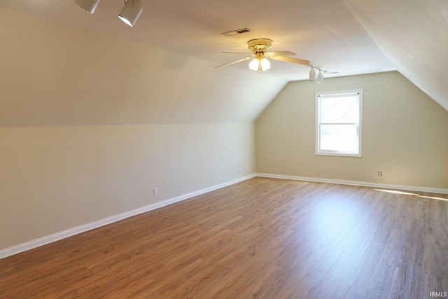 bonus room with ceiling fan, wood finished floors, visible vents, baseboards, and vaulted ceiling