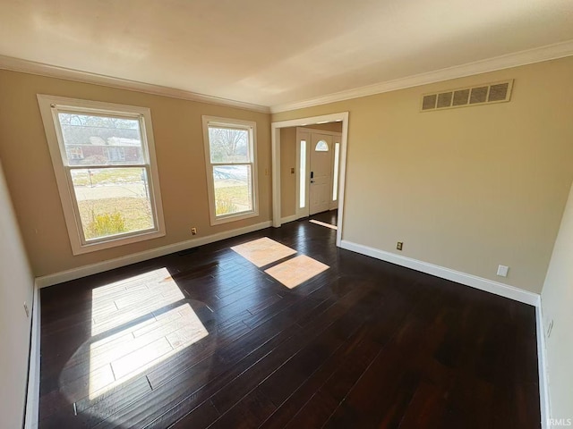 spare room with baseboards, visible vents, dark wood-style flooring, and ornamental molding