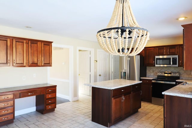 kitchen with a center island, built in desk, stainless steel appliances, backsplash, and a chandelier