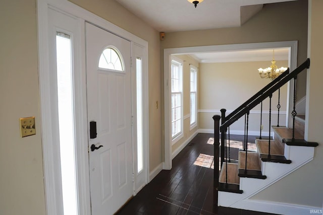 entryway featuring dark wood-style flooring, stairway, baseboards, and an inviting chandelier