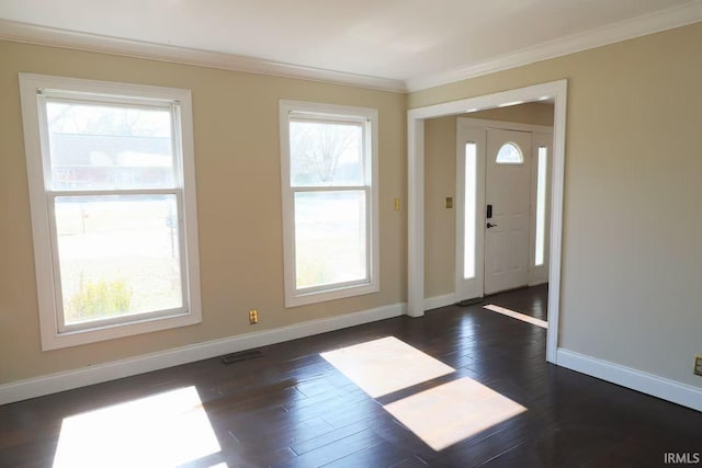 foyer entrance featuring visible vents, crown molding, baseboards, and wood finished floors