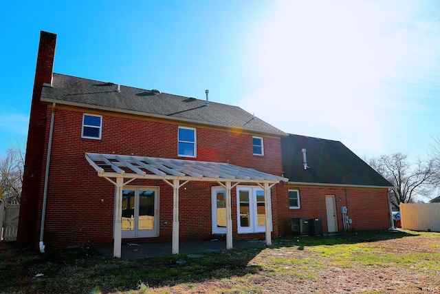 rear view of house featuring brick siding, a chimney, and a pergola