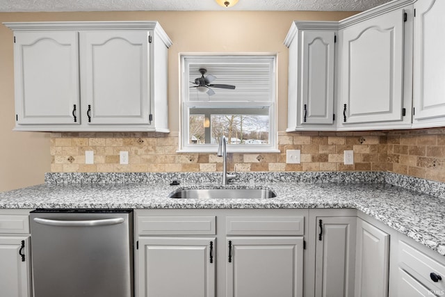 kitchen with a sink, a ceiling fan, white cabinetry, stainless steel dishwasher, and backsplash