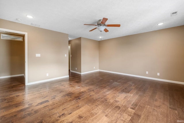 unfurnished room featuring a textured ceiling, visible vents, a ceiling fan, baseboards, and dark wood finished floors