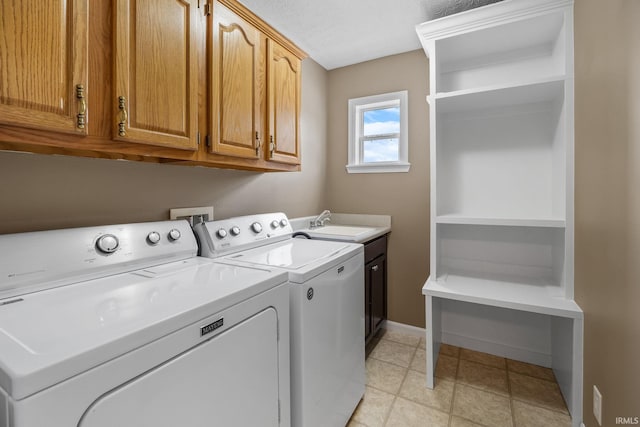 clothes washing area featuring baseboards, a sink, cabinet space, and washer and dryer