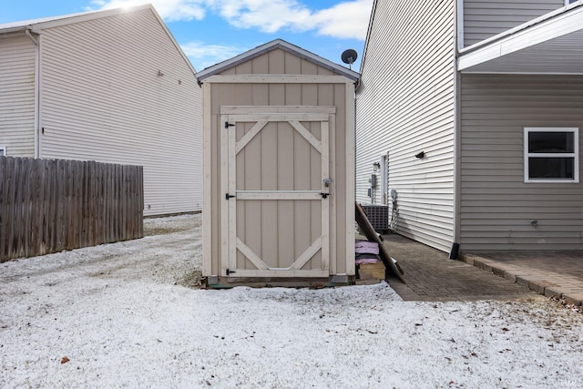 view of shed with central AC unit and fence