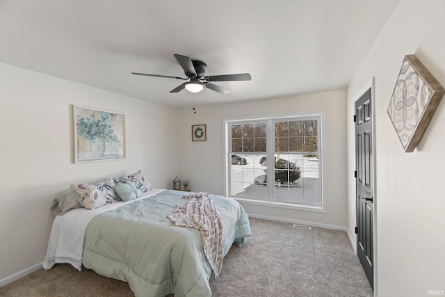 carpeted bedroom featuring ceiling fan, visible vents, and baseboards