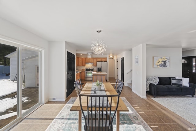 dining space featuring light tile patterned floors, baseboards, visible vents, stairway, and a notable chandelier