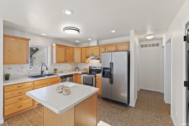 kitchen featuring under cabinet range hood, a sink, visible vents, appliances with stainless steel finishes, and decorative backsplash