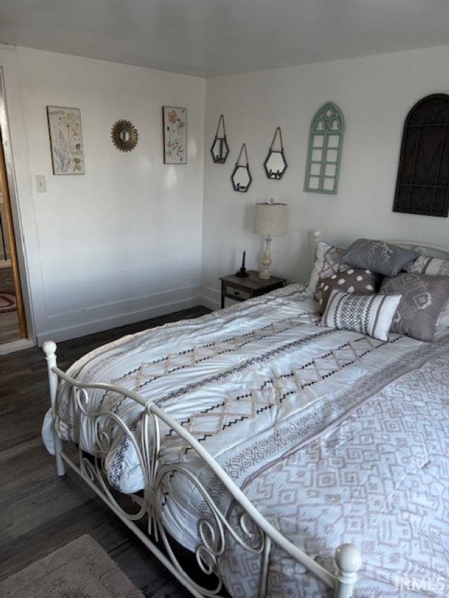 bedroom featuring wood finished floors and baseboards