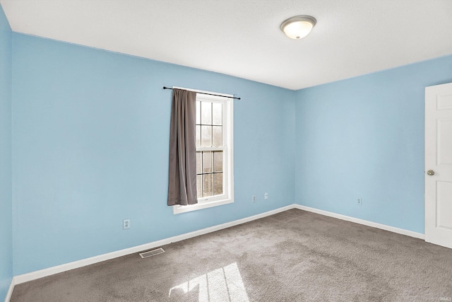 carpeted empty room featuring visible vents and baseboards