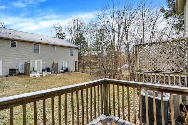 deck featuring cooling unit and a yard