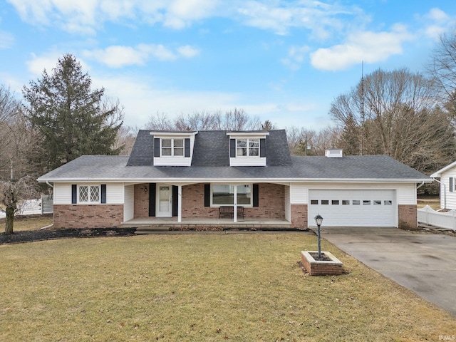 view of front of house with a garage, covered porch, a front yard, and brick siding